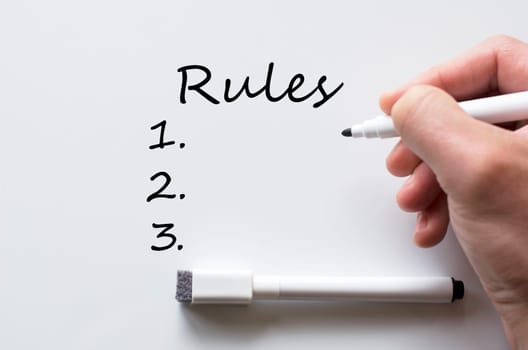 Human hand writing rules on whiteboard