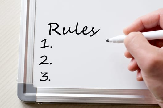 Human hand writing rules on whiteboard