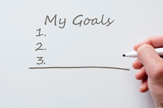 Human hand writing my goals on whiteboard