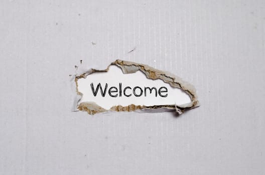 The word welcome appearing behind torn paper.