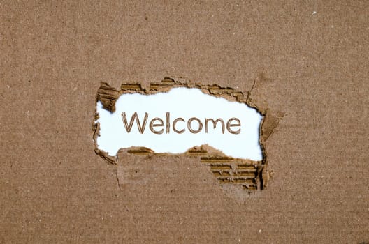 The word welcome appearing behind torn paper.