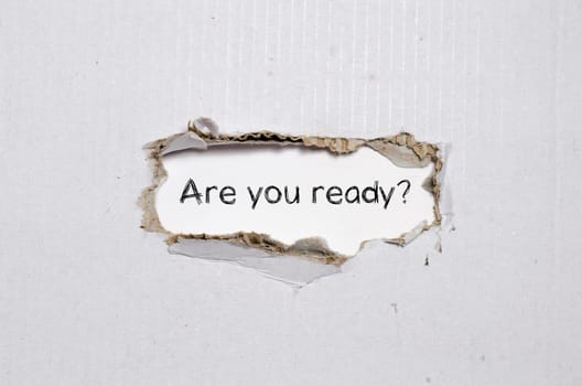 The word are you ready appearing behind torn paper.
