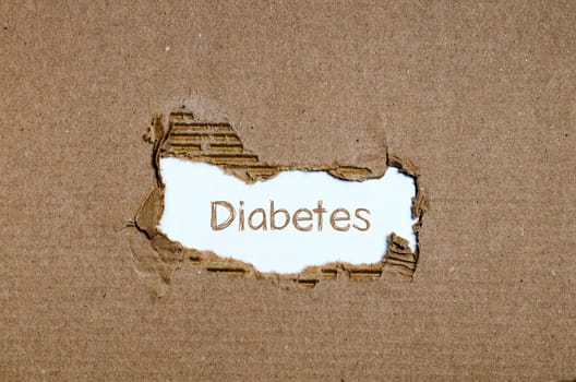 The word diabetes appearing behind torn paper.