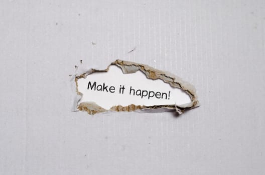 The word make it happen appearing behind torn paper.