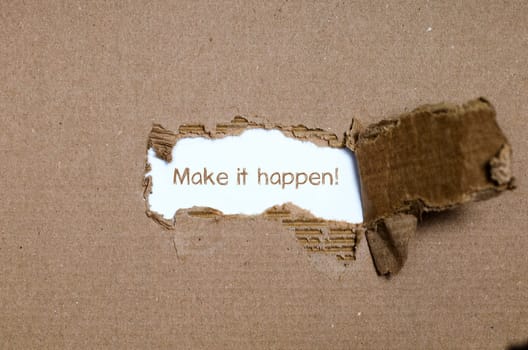 The word make it happen appearing behind torn paper.