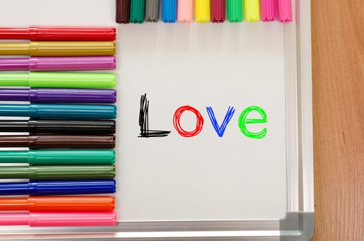 Felt-tip pen and whiteboard on a wooden background