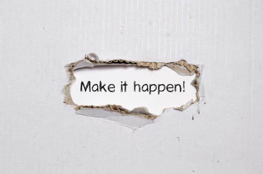 The word make it happen appearing behind torn paper.