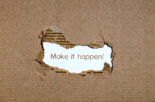 The word make it happen appearing behind torn paper.