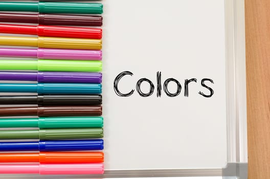 Felt-tip pen and whiteboard on a wooden background