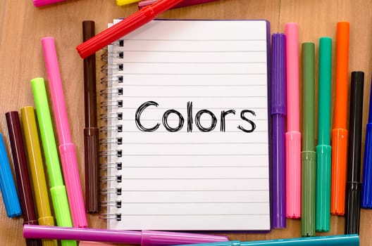 Felt-tip pen and notepad on a wooden background