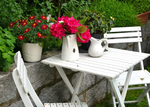 old chair in the garden with flowers in spring