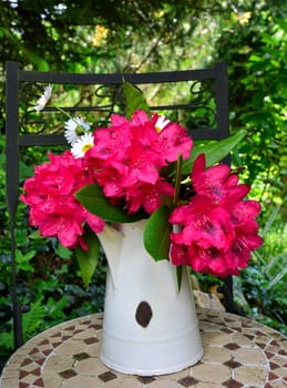 Rhododendron bouquet in a white tin jug