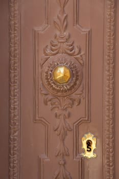 A wood brown door with gold knob and keylock
