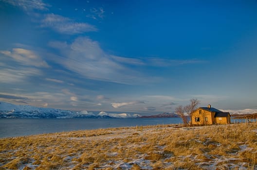 Isolated home and beach on a snowy lake