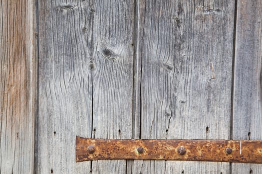 Weathered grey window with his rusty hinge