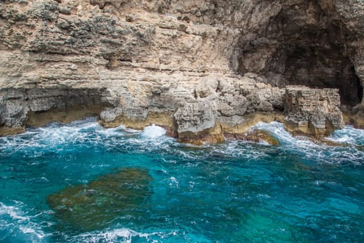 Huge multi colours rocks over a ligth blue water in mediterranean sea