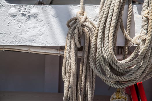 Hanged weathered boat ropes on a blue sea
