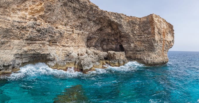 Huge multi colours rocks over a ligth blue water in mediterranean sea