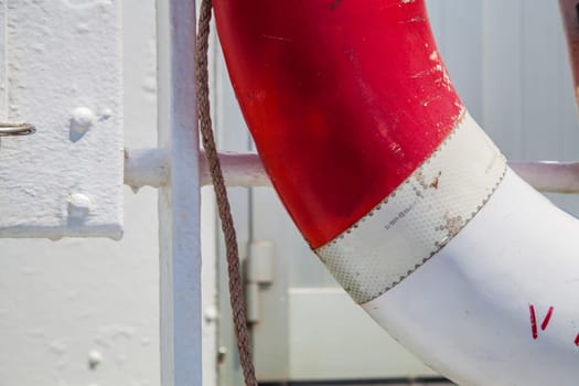 Red and white lifesaver on a white boat