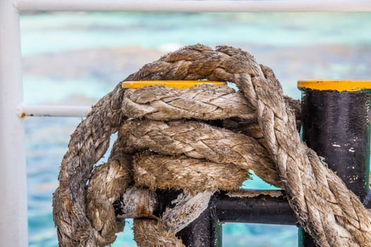 Knotted weathered boat ropes on a blue sea