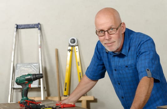 a portrait of mature handyman at DIY workshop