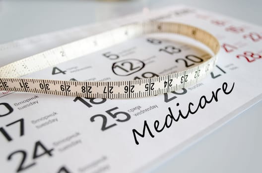 Medicare text concept over tape measure and calendar background..