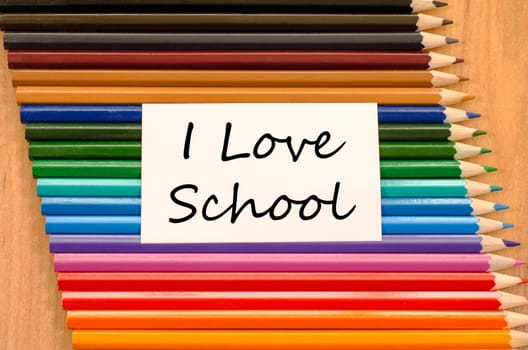 I love school text concept and colored pencil on wooden background
