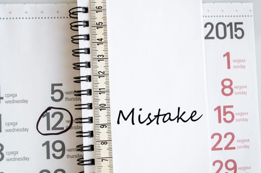 Mistake text concept over tape measure and calendar background..