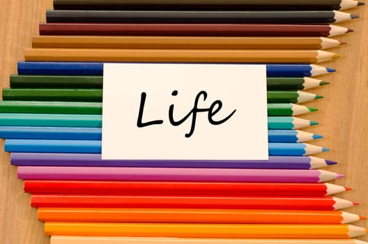 Life text concept and colored pencil on wooden background