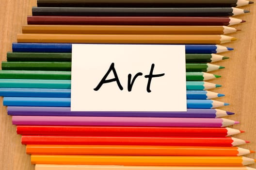 Art text concept and colored pencil on wooden background
