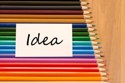 Idea text concept and colored pencil on wooden background