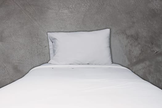 Close up white bedding and pillow on concrete texture background