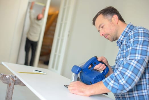 Carpenter using band saw to cut wood