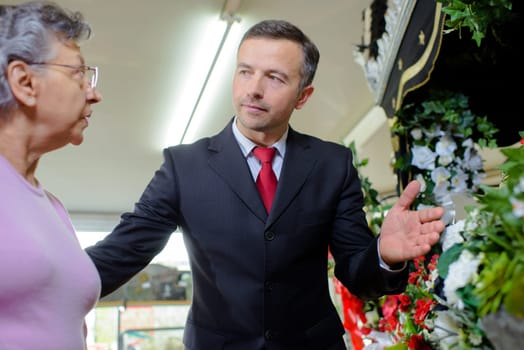 Man advising lady on funeral flowers