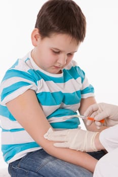 Doctor giving a child injection in arm on isolated image.