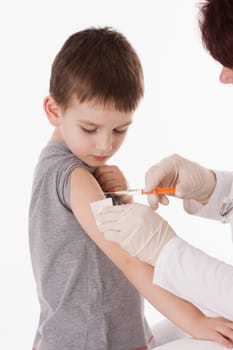 Doctor giving a child injection in arm on isolated image.