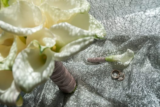 Wedding bouquet of white Calla Marsh Marsh, Bog Arum, Water-Arum, Araceae family. the light of the morning sun, the newlyweds rings