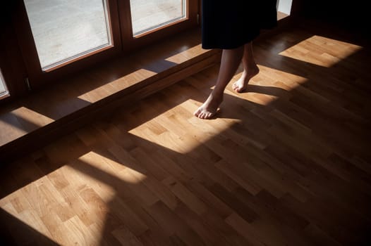 Closeup shot of female feet under bed at morning