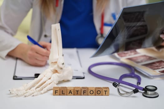 A skilled medical professional carefully examines various flatfoot conditions using detailed anatomical models