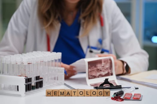 A qualified healthcare professional meticulously reviews blood samples within the specialized hematology laboratory