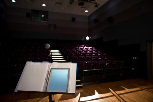 Empty lecture hall with a digital tablet on the podium.