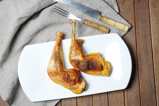 two golden roasted chicken drumstick served on white plate