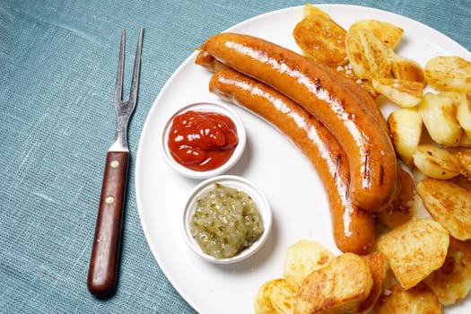 grilled sausages with roasted potatoes, ketchup and cucumber relish