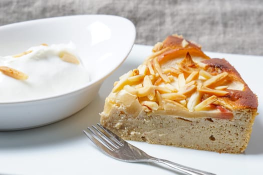 Apple tart. Pie with almonds and sour cream served on a white plate