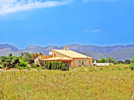 Majorca, Spain - June 28, 2008: Finca / rural country home - tramuntana mountains in the background, meadow in front