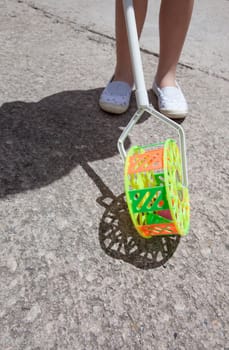 Child with traditional roadrunner wheel toy on street