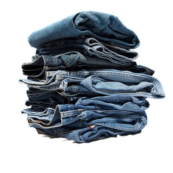 Folded jeans stacked in a pile on white background
