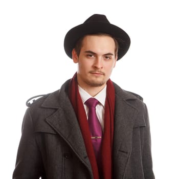 An young adult in a coat with a tie and a hat