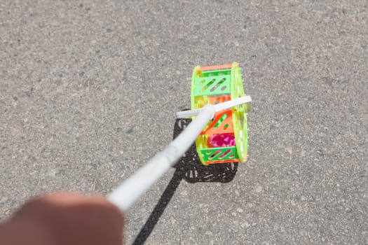 Child with traditional roadrunner wheel toy on street