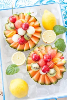 Fresh fruit salad in melon cooled on ice